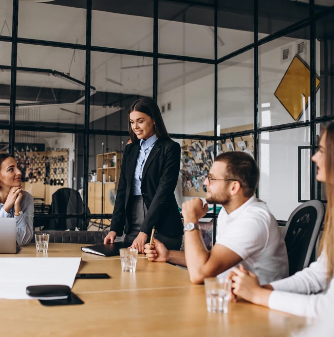 Reunión de trabajo en equipo con una mujer liderando la presentación en una sala de oficina moderna Reunión de trabajo en equipo con una mujer liderando la presentación en una sala de oficina moderna