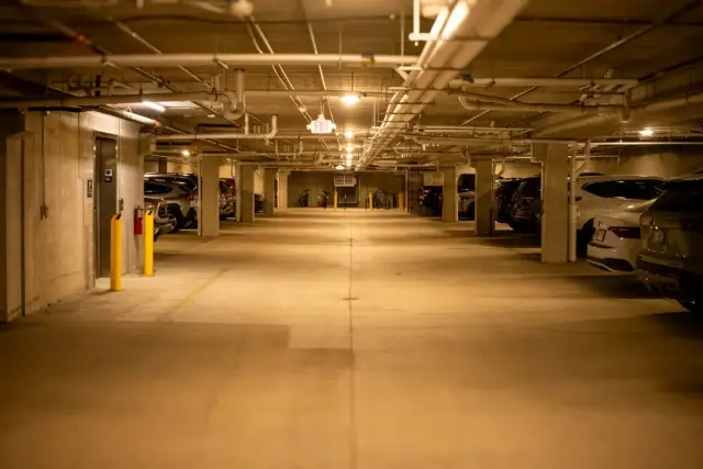 Aparcamiento subterráneo con coches estacionados y columnas de hormigón