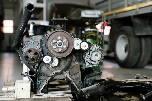 Motor desmontado sobre un palé en un taller con un camión al fondo