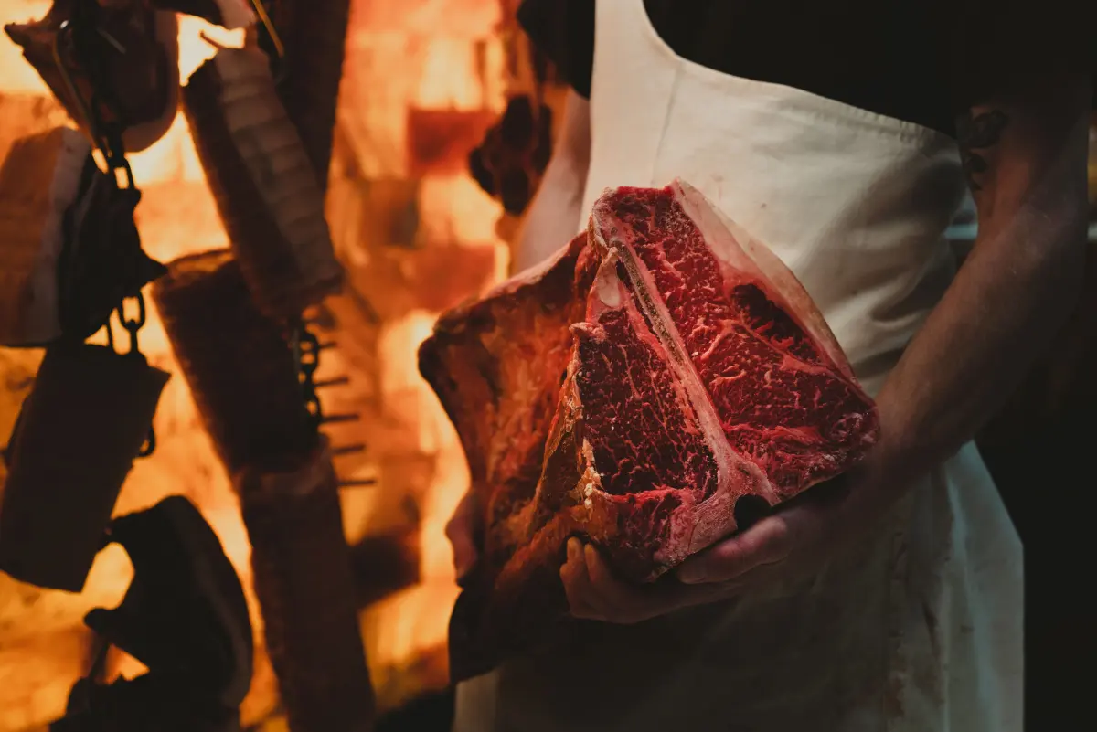Carnicero sosteniendo una pieza de carne en un obrador